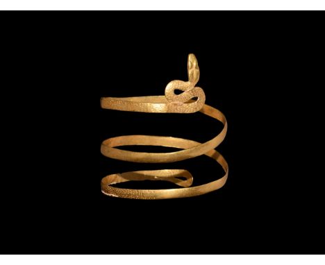 1st century BC-3rd century AD. A flat-section coiled gold arm-ring with texture to each end, recurved tail with loop and undu