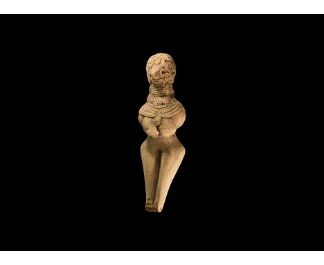 3rd millennium BC. A ceramic figurine of a female with elaborate hair and concentric applied collars with medallion, pointill