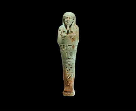 Late Period, 664-332 BC. A pale blue glazed composition shabti with tripartite wig, false beard, arms crossed holding agricul