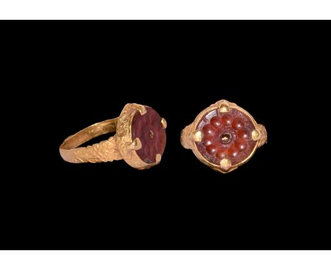 12th-13th century AD. A gold finger ring comprising a flat-section hoop with zigzag detailing, lattice to each shoulder, disc