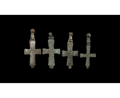 10th-12th century AD. A mixed group of bronze reliquary cross pendants, each with hinged loop, low-relief figural and geometr