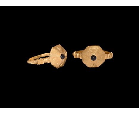 13th-14th century AD. A gold finger ring comprising a slender D-section hoop with cornice shoulders and plaque with starburst