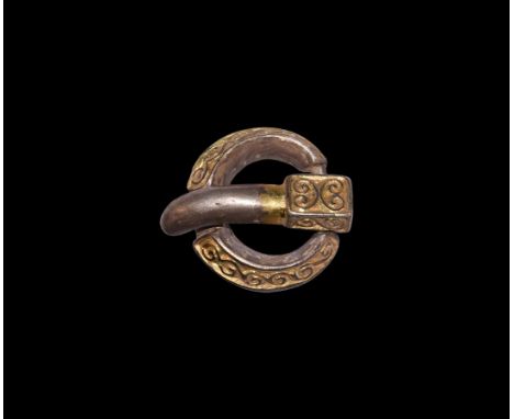 5th-6th century AD. A silver-gilt belt buckle comprising a triangular-section loop with hollow underside, reserved running sc