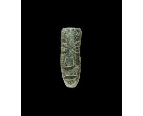 Pliocene Period, 5.2-2.5 million years BP. A fossil mastodon tusk, later carving depicting a human elongated face with promin