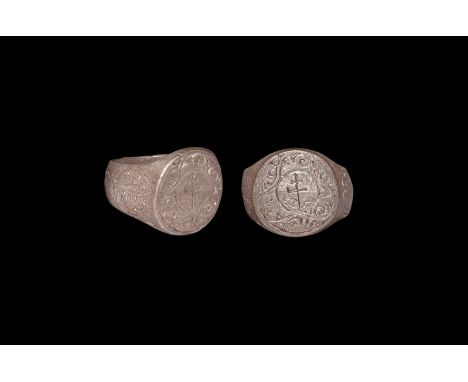 12th-13th century AD. A silver finger ring with broad hoop, scroll detailing to the outer face and rosette to each shoulder, 
