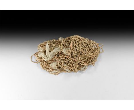 6th-7th century AD. A large group of restrung necklaces, multiple strands of small ceramic beads, in buff, red and brown.   4