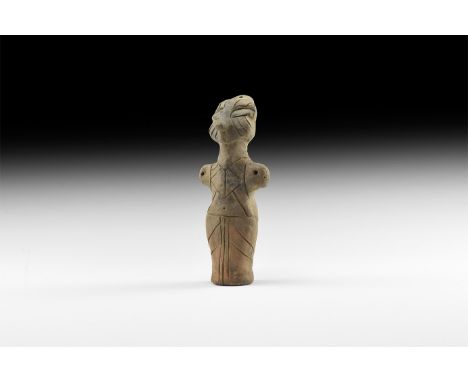 Neolithic, 6th-4th millennium BC. A ceramic figurine of a standing female with lobed headdress, stub arms extended, incised d