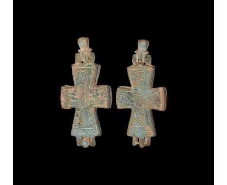 10th-12th century AD. A bronze reliquary cross pendant with hinged loop, low-relief image to each face of a robed figure in o