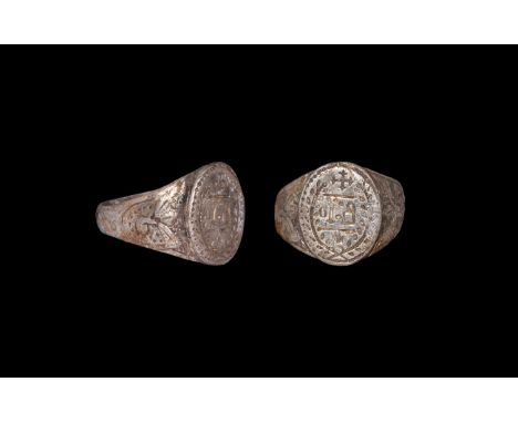 6th century AD. A silver finger ring with flat-section hoop, tapering shoulders with foliage and pellets, ellipsoid bezel wit