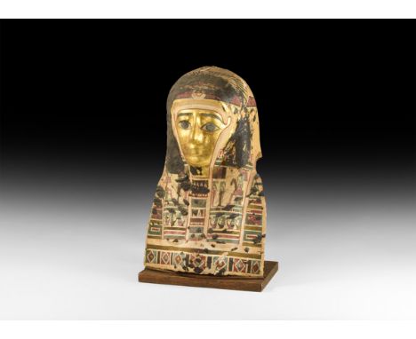 Ptolemaic Period, 332-30 BC. A cartonnage mask with gesso and gilded surface; wearing a tripartite wig with hawk to top of he