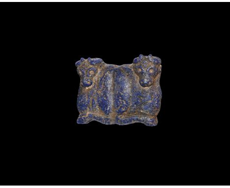 3rd millennium BC. A lapis lazuli carving of a pair of reclining bulls facing away from each other; horns curving to the fron