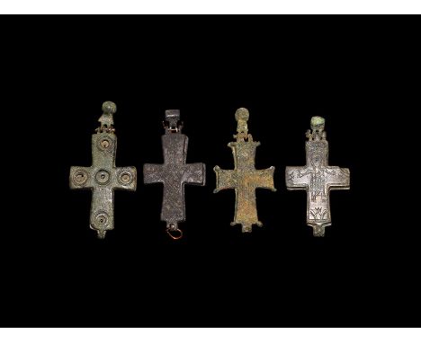 10th-12th century AD. A mixed group of bronze reliquary cross pendants, each with sockets for inset gems and low-relief image