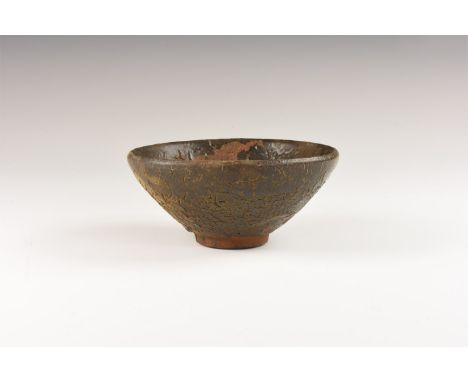 Song Dynasty, 960-1127 AD. A conical ceramic bowl covered in a mottled dark glaze once streaked with fine russet-coloured 'ha