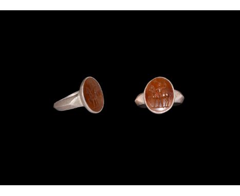 1st century BC-1st century AD. A silver finger ring with D-section hoop, discoid bezel with inset sard cloison, intaglio adva