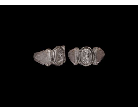 3rd century AD. A silver finger with triangular shoulders and scrolled upper anglers, elliptical bezel with beaded wire colla