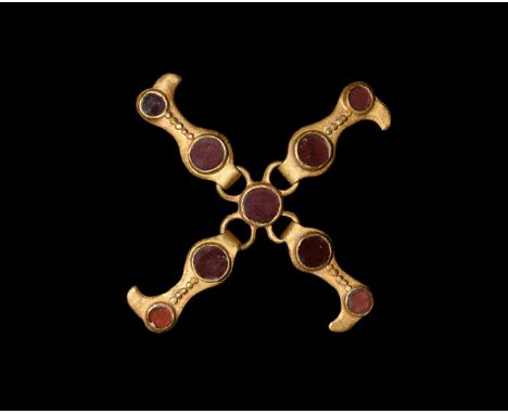 6th century AD. A gold strap distributor comprising a central gold cell with discoid garnet cloison insert, four radiating lo