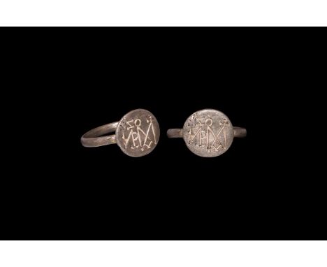 6th-7th century AD. A silver finger ring comprising a round-section hoop, discoid bezel with incised monogram. Cf. Chadour, A