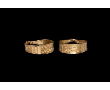 9th-11th century AD. A gold finger ring comprising a flat-section hoop with ends coiled about the shank, pointillé geometric 