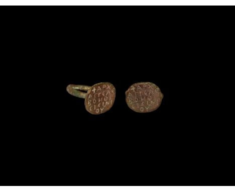 8th-12th century AD. A bronze seal ring with thin hoop and flat oval bezel engraved with cross and inscription; inscription r