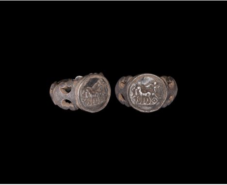 2nd-3rd century AD. A substantial silver finger ring with hoop formed from opposed volute scrolls, keeled shoulders, discoid 