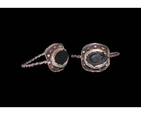 1st-3rd century AD. A silver finger ring comprising a slender twisted hoop, square plaque with central cell and radiating gra