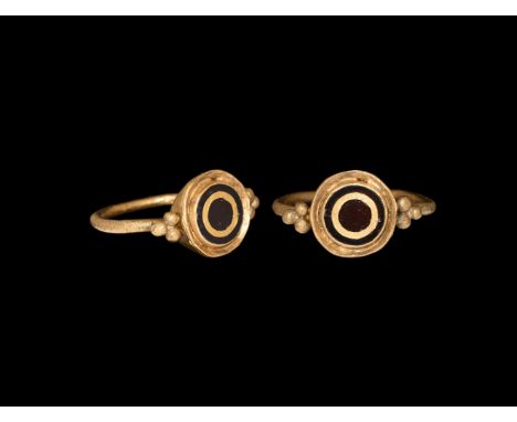 7th-8th century AD. A gold finger ring comprising a round-section hoop, three large granules to each shoulder, drum-shaped be