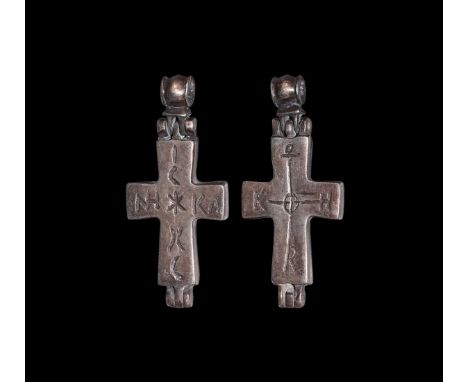 10th-12th century AD. A silver reliquary cross pendant with hinged barrel-shaped loop, obverse with incised legend 'IC*XC', '