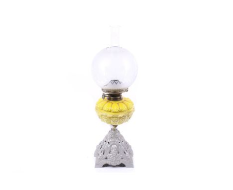 A cast metal and glass oil lamp. Painted base with yellow glass bowl and brass fittings, Etched glass globe shade with glass 