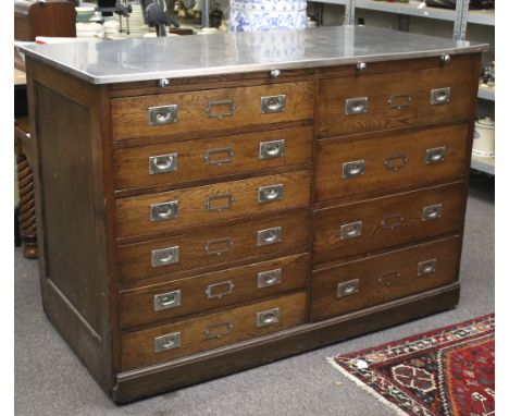 A mid century large oak bank of drawers. The left hand side having six drawers flanked by a set of four drawers. Both with a 