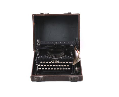 An Erika portable manual typewriter. S/n. 62426. In black with yellow lettering, H10cm x W29cm x D30cm. 