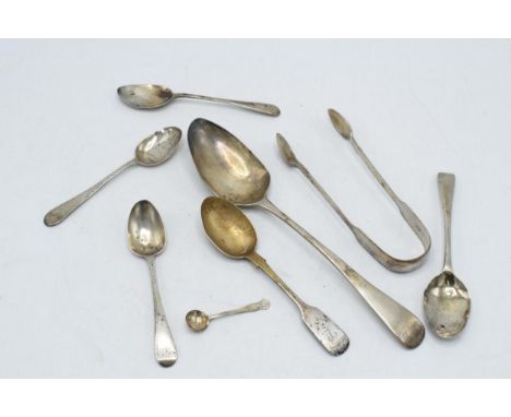 A collection of hallmarked silver flatware to include sugar tongues, Georgian and later spoons, 172.4 grams.  