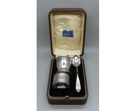 A silver spoon, egg cup and napkin ring, 71g, cased 