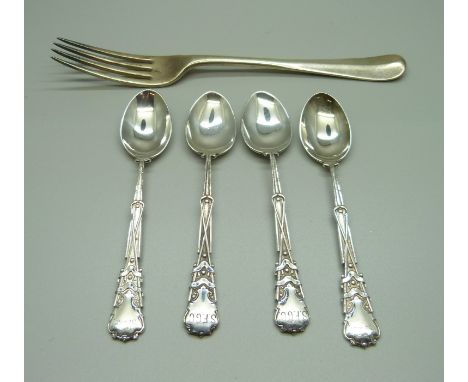 A silver fork and a set of four silver spoons with golf detail, 157g 