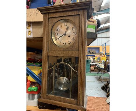 A VINTAGE WOODEN WALL CLOCK WITH BRASS AND GLASS DETAIL IN THE DOOR H:61CM 