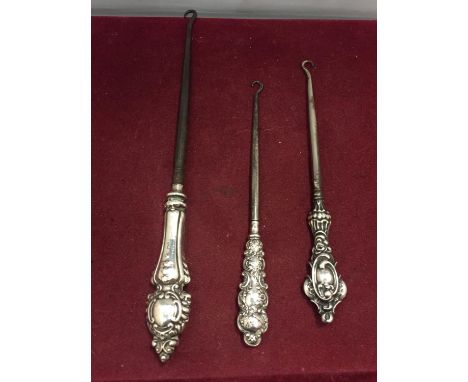 THREE HALLMARKED SILVER HANDLED BUTTON HOOKS TO INCLUDE A BIRMINGHAM 1914/1915 
