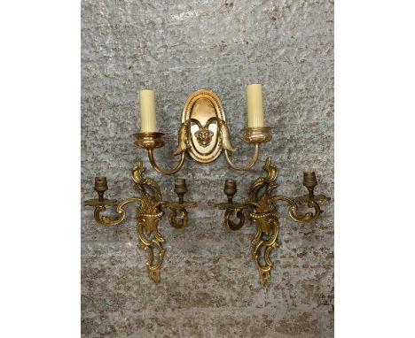 A PAIR OF ORNATE METAL GILT TWIN WALL LIGHTS AND A SINGLE METAL TWIN WALL LIGHT WITH LION'S HEAD DECORATION 