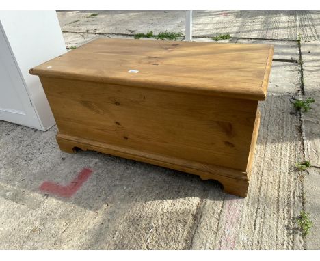 A MODERN PINE BLANKET BOX ON BRACKET FEET 