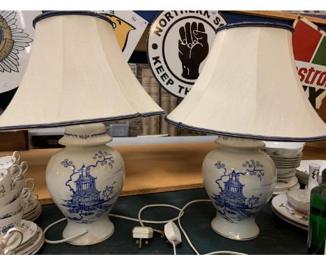 A PAIR OF CERAMIC BASED BLUE AND WHITE TABLE LAMPS COMPLETE WITH SHADES H: TO BOTTOM OF BULB 37CM APPROX 