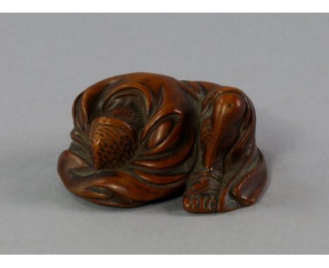 A Japanese boxwood netsuke of a crouching man, 19th/early 20th century, modelled clothed with his face to the ground, reveale