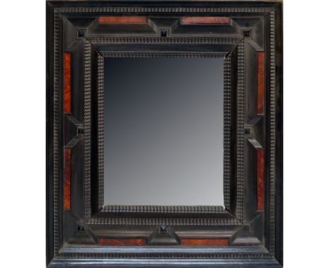 A Flemish ebonised wood mirror frame, 17th century, with ripple moulded concentric bands, inset with rectangular panels of to