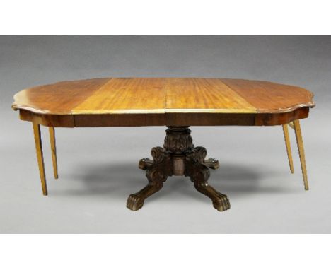 A Victorian style mahogany dining table, the shaped rectangular top with scroll carved corners, raised on pedestal plinth, tr