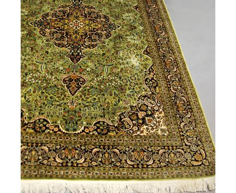 An Indian Kashan pattern silk carpet with pole medallion in a light green field, 280 x 188 cm  CONDITION REPORT: Fairly good 