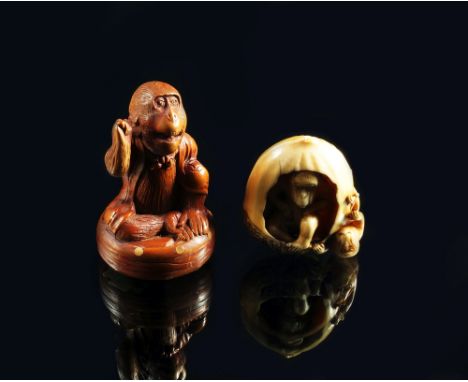 A Japanese ivory netsuke, 19th century, carved in the form of a nut, the interior housing a monkey with its child hanging fro