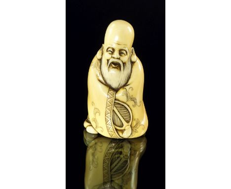 A Japanese ivory netsuke of an Immortal, late 19th/20th century, carved wearing a long robe, with a fan within its folds, sig