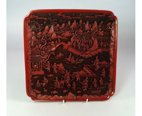 A Chinese imitation cinnabar lacquer tray, 20th century, probably Bakerlite, moulded with scenes of classical gardens in land