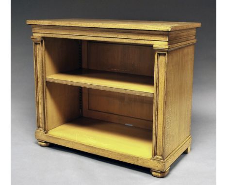 A Gothic style oak bookcase, 20th century, the rectangular top over single shelf, flanked by inset columns, raised on bun fee