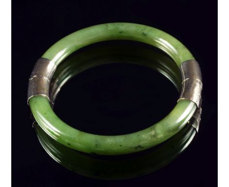 A Chinese spinach green jade and metal mounted bangle, 7.7cm diameter CONDITION REPORT: no condition issues