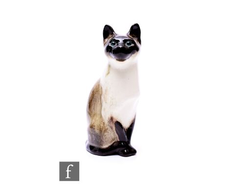 A Winstanley Siamese Cat, modelled sitting, with streaked graded chestnut brown glazes, and foiled blue glass eyes, painted m