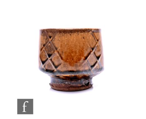 Phil Rogers, a studio pottery footed drinking vessel, of square form, hatched moulded motifs to each face, tonal brown glaze,
