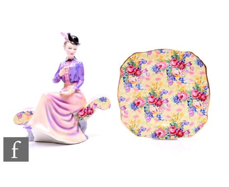 A Royal Winton Welbeck chintz figurine, modelled as an Edwardian lady drinking tea on a chintz pattern scroll end chaise, lim